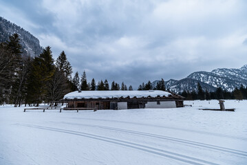 Fototapeta premium Hütte im Schnee mit Langlaufspuren am Lödensee bei Ruuhpolding 