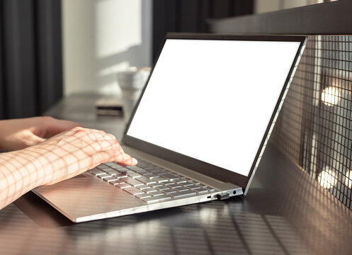 Hands typing on laptop keyboard with computer mockup screen. photo