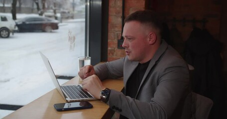 Online communication. A man sitting in a cafe decides the working moments