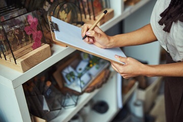 Professional florist writing on a blank sheet of paper