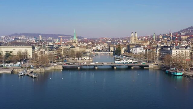 Aerial footage the Limmat river that flow through Zurich historic and city center with the cathedral in Switzerland on a sunny day. Shot with a forward motion