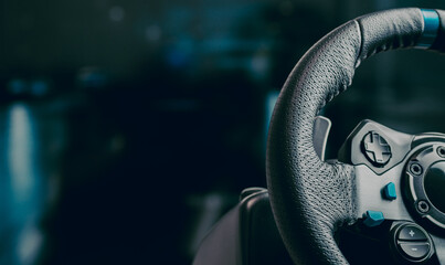 Technology, gaming, entertainment and people concept - young man playing car racing video game at home and steering wheel