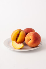 ripe peaches on a plate, white background