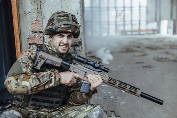 Military man in the form holds in the hands of a big rifle, looks like opponents from the corner.