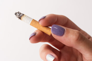 hand with lit cigarette, painted nails, white background