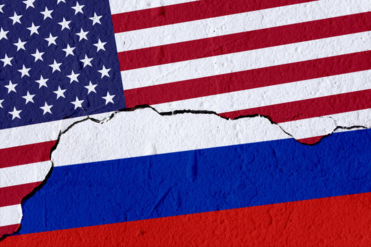 National flags of America and Russia painted on concrete broken wall. Cracked wall texture showing diplomatic relations and war concept. 