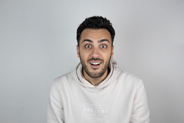 Obraz premium Getting good news. Cheerful, excited young boy is standing on gray background. He is so happy. Open mouth. 