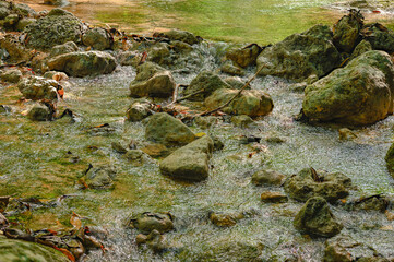 Photography of a small mountain stream, background on the wall. Wide angle.