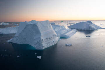 Fototapeta na wymiar Enormes icebergs al atardecer desde punto de vista aéreo