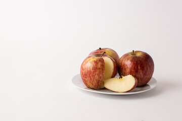 ripe red apples on a plate, white background