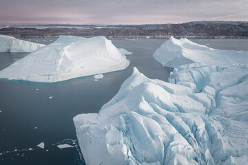 enormes icebergs de formas caprichosas flotando sobre el mar desde punto de vista aéreo