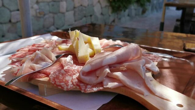 platter of typical Italian cold cuts and cheeses with a glass of wine