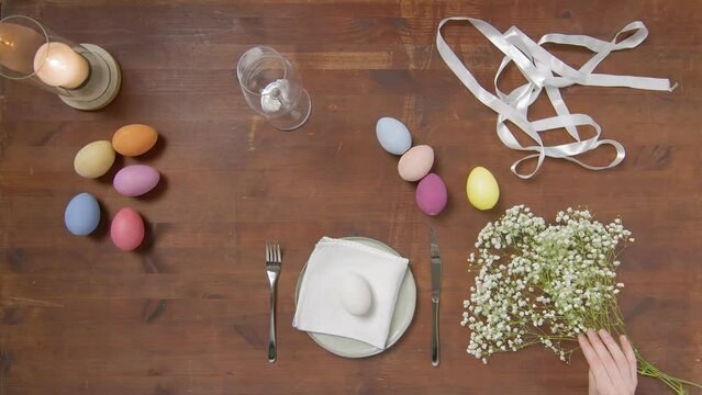 Top view of a table with items to create a composition for Easter. Women's hands arrange objects on the table. Church holiday-Easter