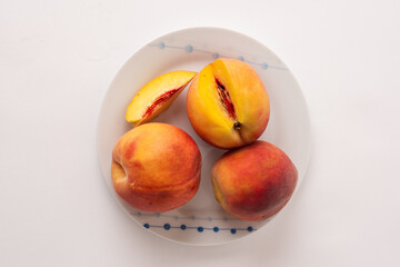 ripe peaches on a plate, white background