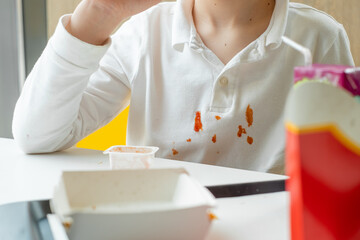Dirty ketchup stains on white clothes. Kids eat unhealthy fat food. daily life stain concept. High...