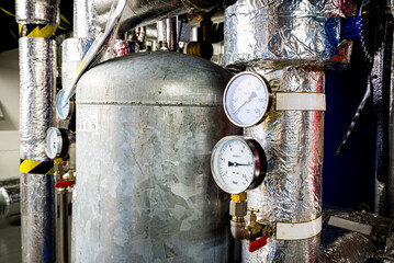 Barometers on pressure pipes, underground premises of the factory with heat and water distribution technology