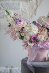 A luxurious bouquet of flowers in a hat box. Composition with pink and white flowers and eucalyptus in a round box. Modern Floristry.