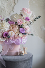A luxurious bouquet of flowers in a hat box. Composition with pink and white flowers and eucalyptus in a round box. Modern Floristry.