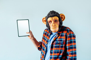 Man in monkey mask using tablet.