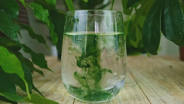 Liquid chlorophyll in a glass of water. Selective focus.