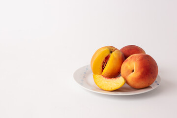 ripe peaches on a plate, white background