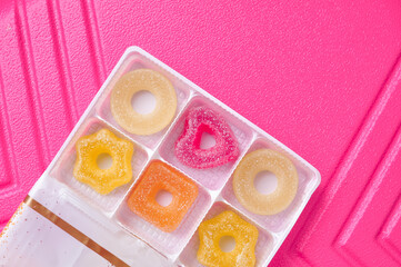 Sweet sugar marmalade on pink background 