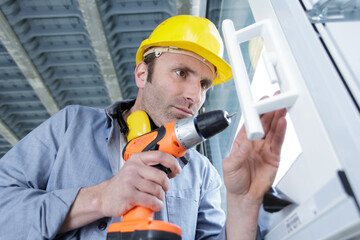 mature man is drilling a window