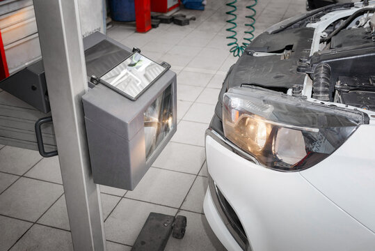 Auto repair service. Adjusting the car headlight light