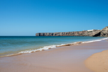 Empty beach at Sagres, Portugal. Blue sky, no waves.