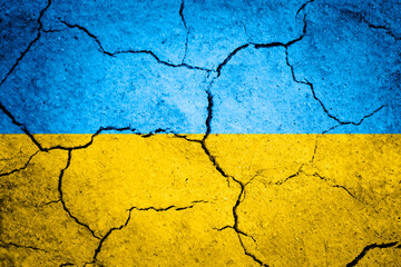 Textured background of cracked dry earth in the shape of ukrainian flag colors.