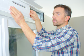 Fototapeta premium Man repairing a roller shutter