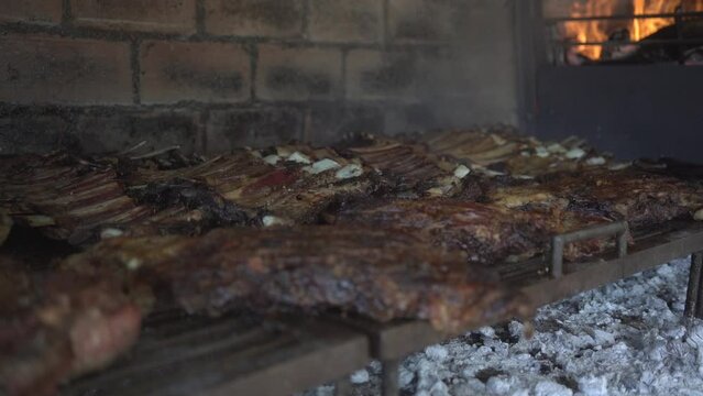 Barbecue. Meat cuts warming on the embers on an iron grill. Traditional Argentinian bbq.