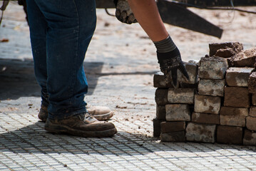 construction worker moving stone debris by hand