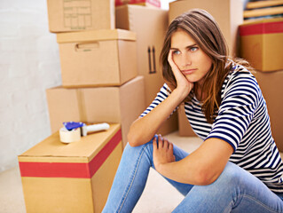 Will these boxes ever end. Shot of an attractive young woman busy moving house.