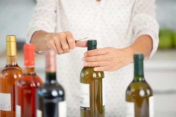 woman opening a wine bottle with the traditional corkscrew