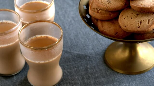 Home-baked biscuits jeera cumin biscuits and masala chai. Table spin.