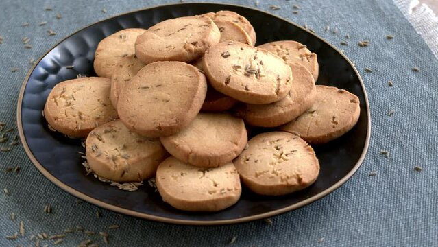 Homemade cumin spice biscuits on a plate. Indian cuisine. Table spin.