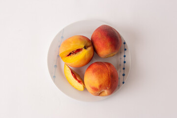 ripe peaches on a plate, white background