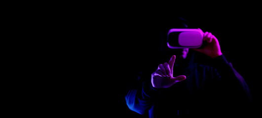 Vr goggles virtual reality. Young man in digital helmet for 3d virtual reality game isolated on black neon background. Study and virtual world in 3D simulation.