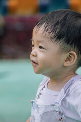 Portrait​ image of​ 1-2 years old​ childhood​ child. Face of smile and laugh Asian​ boy in head shot. Happy​ kid playing​ at the park playground