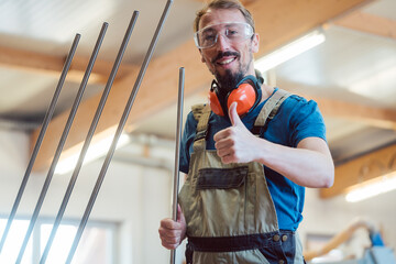 Stairway maker in his workshop giving thumbs-up