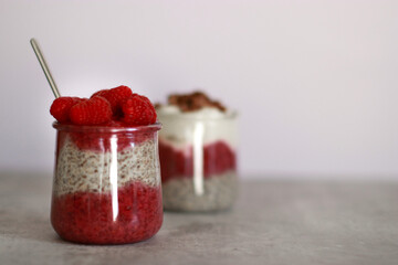 Two glasses of chia pudding dessert with raspberry