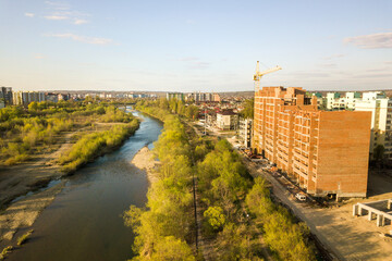 Aerial view of tall residential apartment buildings under construction and Bystrytsia river in Ivano-Frankivsk city, Ukraine.