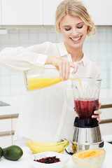 Juicing is both healthy and nutritious. A beautiful young woman making a healthy shake with her blender.