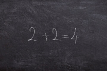 Two pus Tow equals four written with chalk on School Board math class