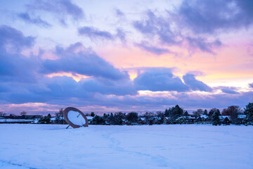 Winter sunset scene at Cranmer Park in the Hilltop neighborhood in Denver, Colorado with its iconic Sundial and view of the mountain range in the distance. - obrazy, fototapety, plakaty