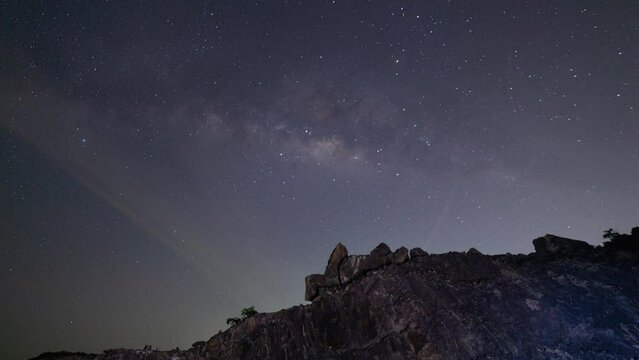 Time lapse Milky way galaxy stars Night to day Timelapse seen in Phuket Thailand Beautiful Nature in the night sky. Astro timelapse tracking shot of Milky Way with mountain rocks in the foreground