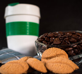 Coffee beans, cookies and plastic thermos for hot drinks on black background