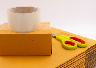 Cardboard box with scotch tape and scissors on a white background, Online sales ideas.