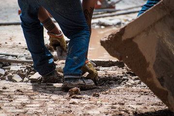 construction worker moving stone debris by hand
